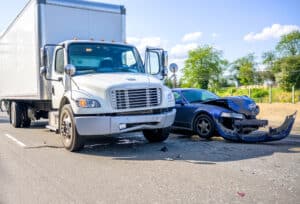 A semi truck and a car side by side after a commercial vehicle crash